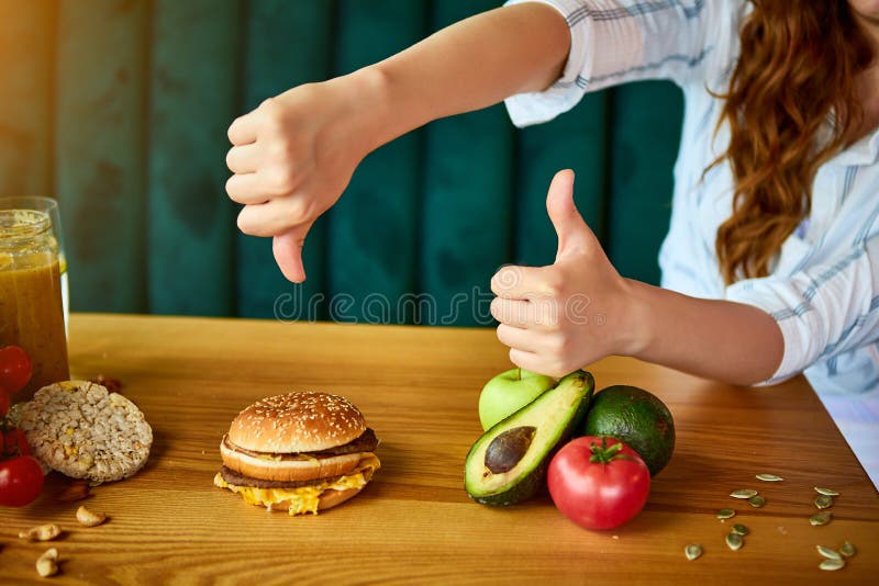 Une femme refuse de manger un hamburger malsain Aliments bon marché contre régime sain photographie stock Une femme refuse de manger un hamburger malsain Aliments bon marché contre régime sain photographie stock