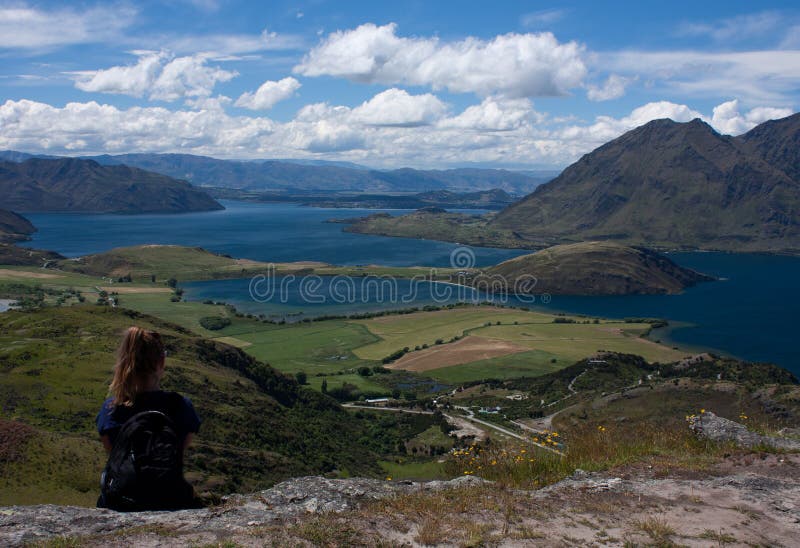 Une femme reposant et regardant le lac Wanaka près de la ville Wanaka au Nouvelle-Zélande image libre de droits Une femme reposant et regardant le lac Wanaka près de la ville Wanaka au Nouvelle-Zélande image libre de droits
