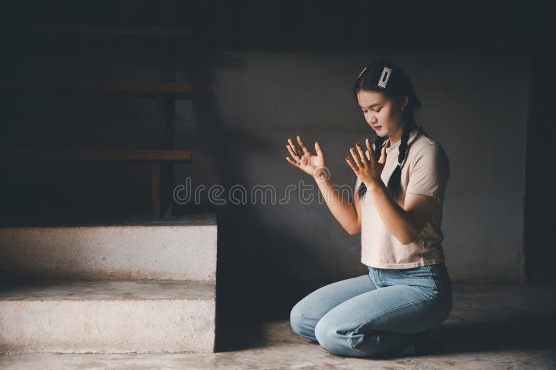 Une femme s'agenouillant pour prier pour le culte Dieu à la maison. Les chrétiens prient jésus christ pour le calme. les gens ont image stock