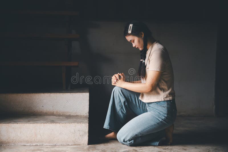 Une femme s'agenouillant pour prier pour le culte Dieu à la maison. Les chrétiens prient jésus christ pour le calme. les gens ont photo libre de droits