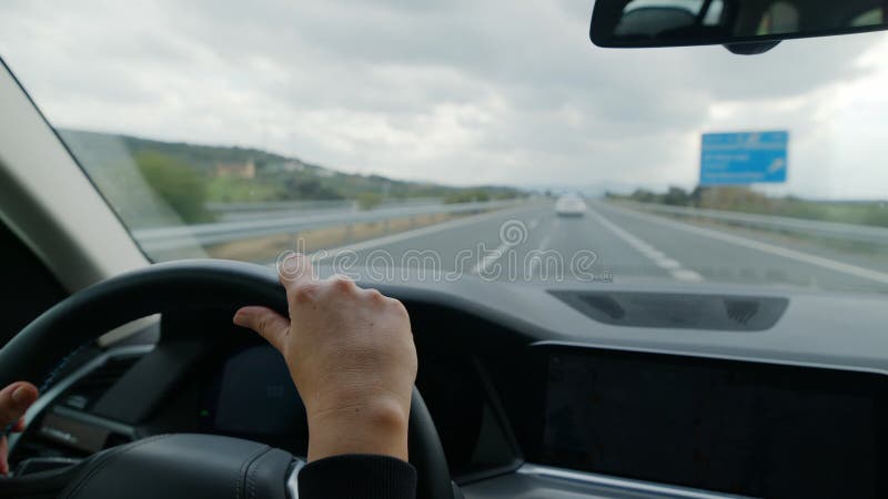 Une femme se rend au volant ou se déplace en voiture sur une autoroute quelque part en Europe. Route bien entretenue entre colline banque de vidéos