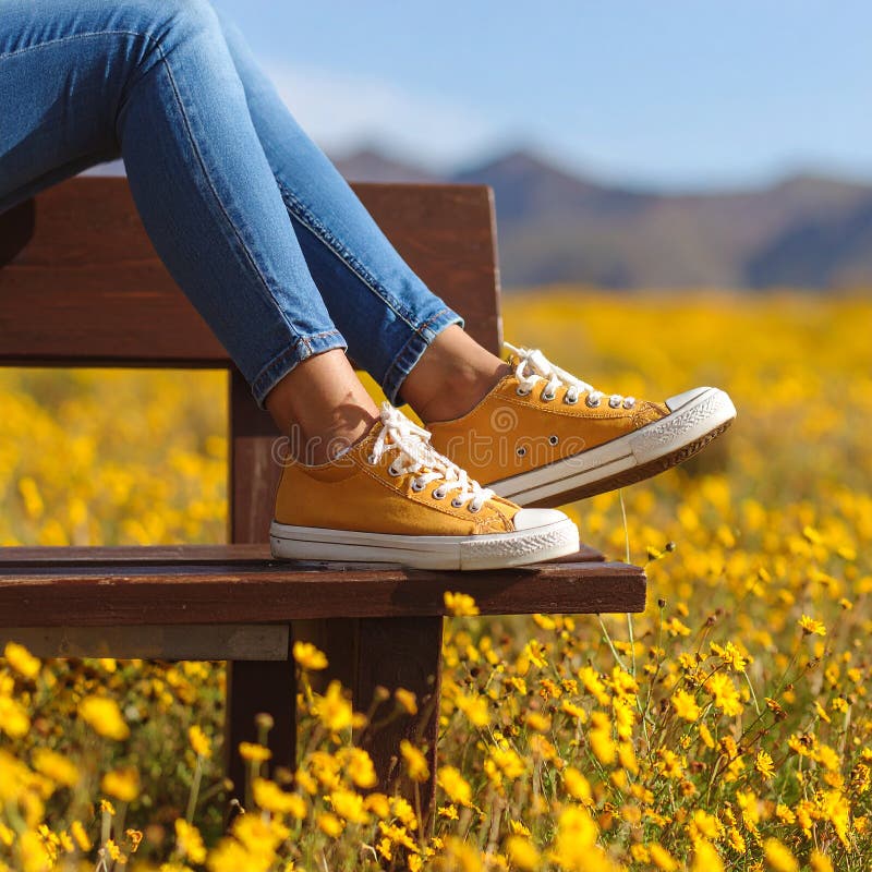 Une femme se reposant avec ses jambes soutenue sur un banc au milieu d'un champ de jaune illustration stock