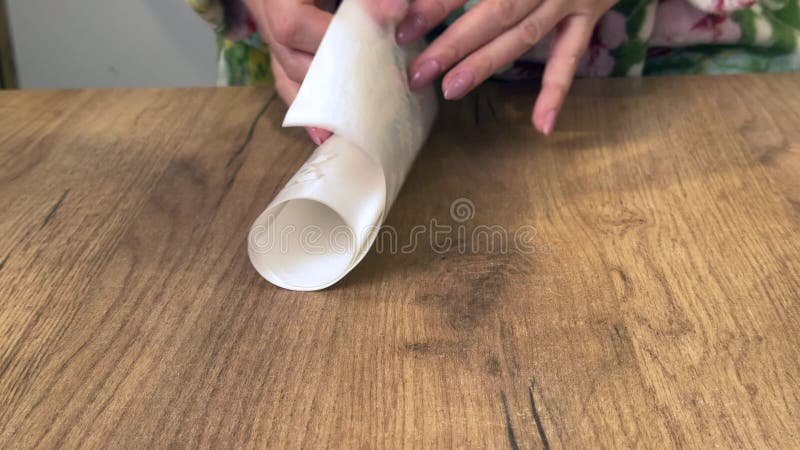 Une femme sort de l'emballage une feuille d'autocollants de fenêtre. les autocollants sont en forme de flocons. closeup. vertical banque de vidéos