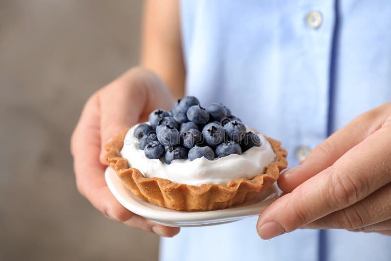 Une femme tenant une assiette avec une tarte aux bleuets Délicieuses pâtisseries images libres de droits Une femme tenant une assiette avec une tarte aux bleuets Délicieuses pâtisseries images libres de droits