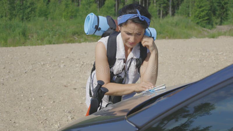 Une femme utilise une carte et pense un itinéraire pour la randonnée clips vidéos