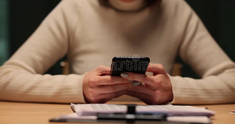 Une femme utilise le téléphone à table tard dans la nuit au bureau banque de vidéos