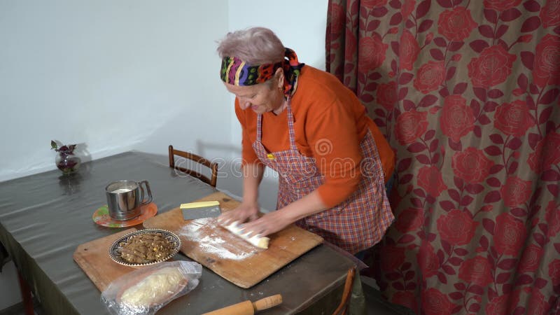 Une femme âgée fait des tartes avec de la viande. pâte maison. Grand-mère cuisine à la maison. Mains sur la cuisine de table clips vidéos