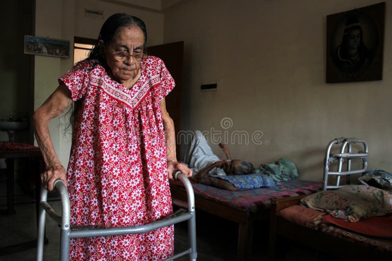 An Elderly lady helping herself in an OLD AGE home at Behala in Eastern Indian state of  Kolkata, West Bengal. Old People being left by their near and dear ones have no where to go , except this homes, which provides an air of breadth to their dull life. Some have their children in far off cities and quite well off, but have no time to serve their parents ,are left at the old age homes. It’s a pity that this elderly people, who have been an army officer, or a teacher or a singer at the peak of their life is now left at the mercy of this homes. This old age home named “Shantiniloy”, is situated at the far off corner of Kolkata among tranquility.
Within three decades, the number of older adults has more than doubled i.e. from 43 million in 1981 to 92 million in 2011 and is expected to triple in the next four decades i.e., 316 million. The life expectancy at birth has also increased from 62.5 years in 2000 to 66.8 years in 2011 and next census data is awaited.
There has been a steady growth of old age homes, because of an exceptional increase in the number and proportion of older adults in the country, rapid increase in nuclear families, and contemporary changes in psychosocial matrix and values often compel this segment of society to live alone or in old age homes. This group of people is more vulnerable to mental and health problems. An Elderly lady helping herself in an OLD AGE home at Behala in Eastern Indian state of  Kolkata, West Bengal. Old People being left by their near and dear ones have no where to go , except this homes, which provides an air of breadth to their dull life. Some have their children in far off cities and quite well off, but have no time to serve their parents ,are left at the old age homes. It’s a pity that this elderly people, who have been an army officer, or a teacher or a singer at the peak of their life is now left at the mercy of this homes. This old age home named “Shantiniloy”, is situated at the far off corner of Kolkata among tranquility.
Within three decades, the number of older adults has more than doubled i.e. from 43 million in 1981 to 92 million in 2011 and is expected to triple in the next four decades i.e., 316 million. The life expectancy at birth has also increased from 62.5 years in 2000 to 66.8 years in 2011 and next census data is awaited.
There has been a steady growth of old age homes, because of an exceptional increase in the number and proportion of older adults in the country, rapid increase in nuclear families, and contemporary changes in psychosocial matrix and values often compel this segment of society to live alone or in old age homes. This group of people is more vulnerable to mental and health problems.