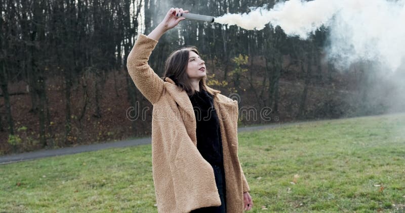 Une femme émet un signal d'alarme avec de la fumée blanche Jeune fille de Hipster avec une bombe à fumigène banque de vidéos