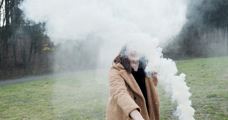 Une femme émet un signal d'alarme avec de la fumée blanche Jeune fille de Hipster avec une bombe à fumigène banque de vidéos