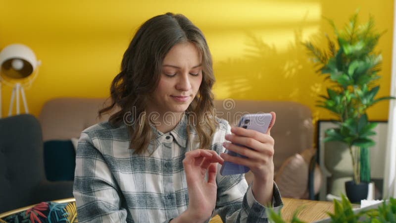Une fille bavarde dans les messagers sur smartphone. étudiant détente avec téléphone portable banque de vidéos