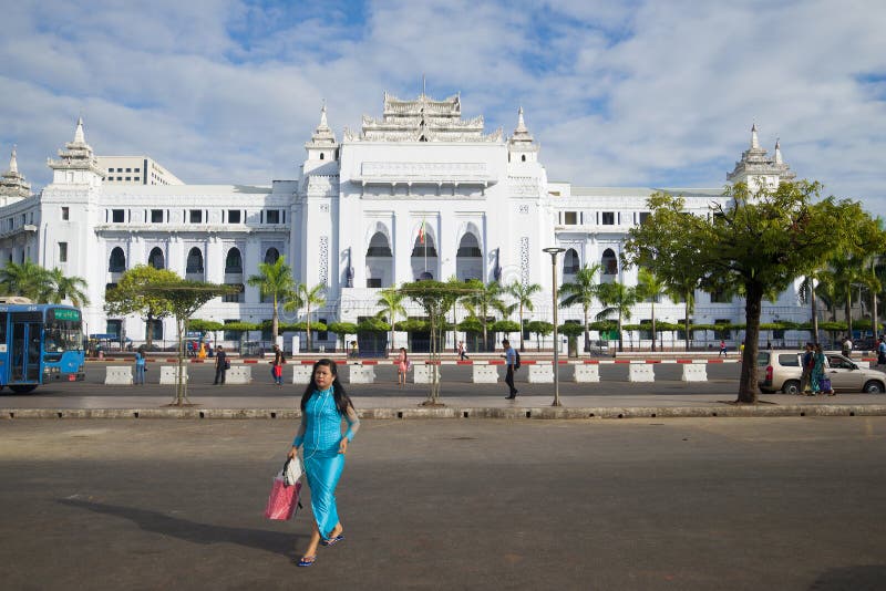 Une fille birmanne traverse la rue à l'extérieur du bâtiment de municipalité de ville, Yangon images libres de droits Une fille birmanne traverse la rue à l'extérieur du bâtiment de municipalité de ville, Yangon images libres de droits