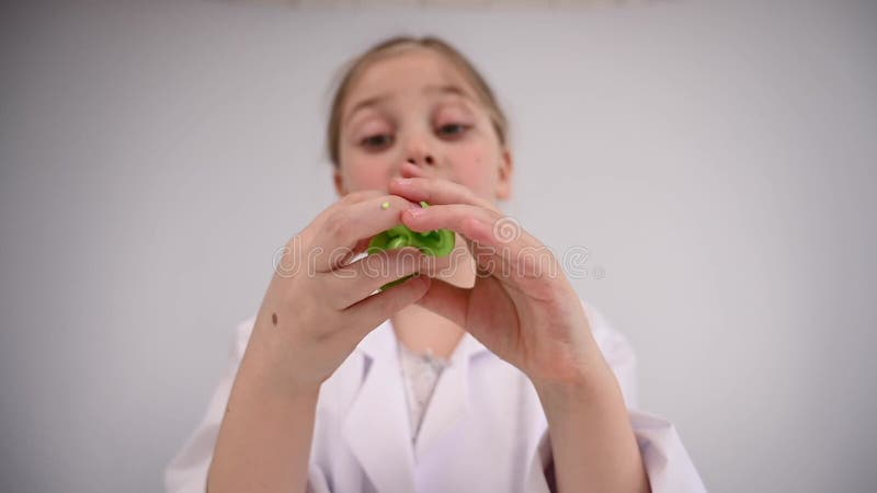 Une fille caucasienne faisant des expériences chimiques sur fond blanc. Faire du slime. clips vidéos