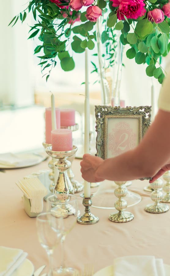Une fille, une femme décore une table de fête de mariage photos libres de droits Une fille, une femme décore une table de fête de mariage photos libres de droits