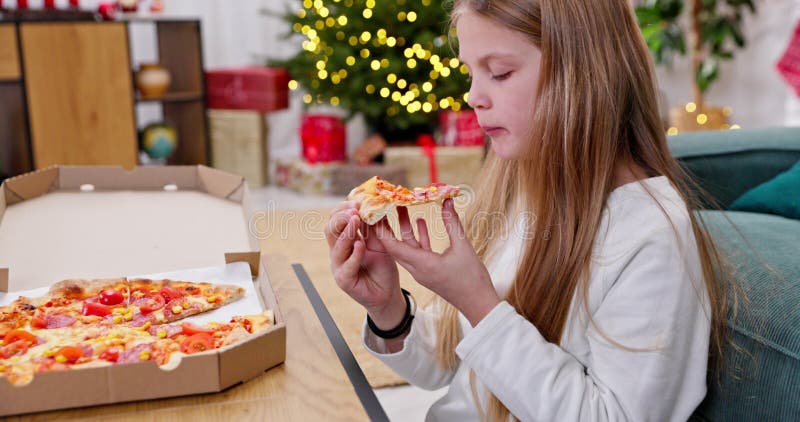 Une fille joyeuse savoure une délicieuse pizza dans un cadre de vacances banque de vidéos