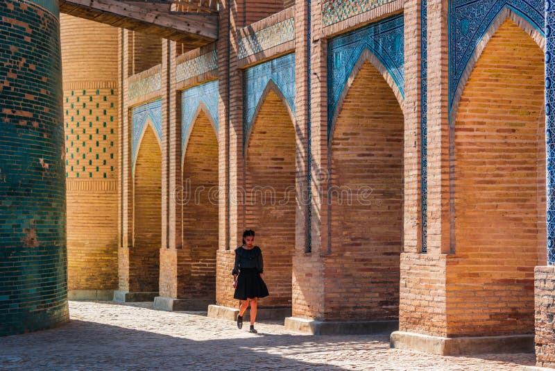 Une fille marchant au mineur de Kalta dans Khiva, l'Ouzbékistan photographie stock Une fille marchant au mineur de Kalta dans Khiva, l'Ouzbékistan photographie stock