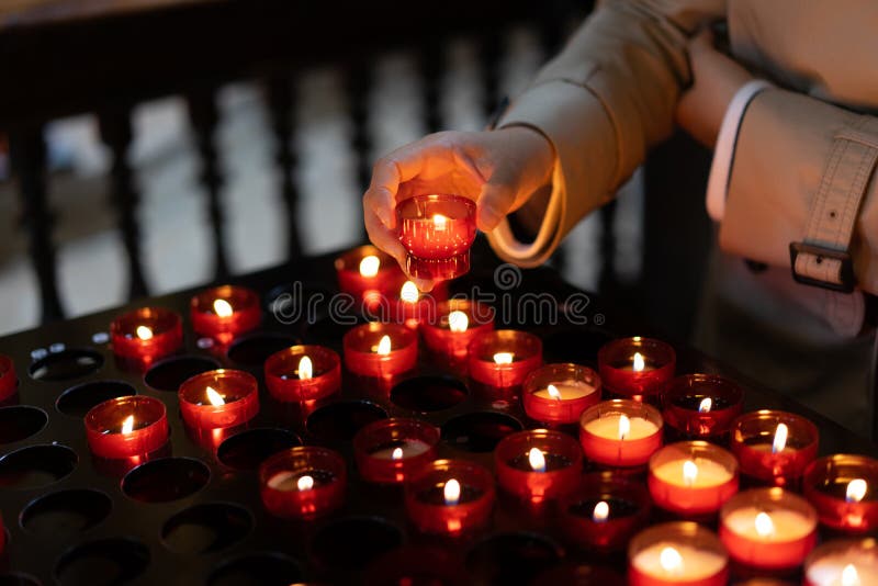 Une fille tient la bougie et prie près de l'autel dans l'église image libre de droits Une fille tient la bougie et prie près de l'autel dans l'église image libre de droits