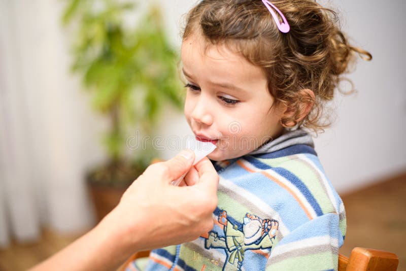 A three-year-old girl spits into a saliva test tube for covid19 antigens. A three-year-old girl spits into a saliva test tube for covid19 antigens.