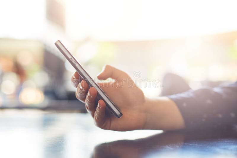 Une fin de la main du ` s de femme tenant le téléphone portable envoyant des messages Jeune femme stockant le service de mini-mes images libres de droits Une fin de la main du ` s de femme tenant le téléphone portable envoyant des messages Jeune femme stockant le service de mini-mes images libres de droits