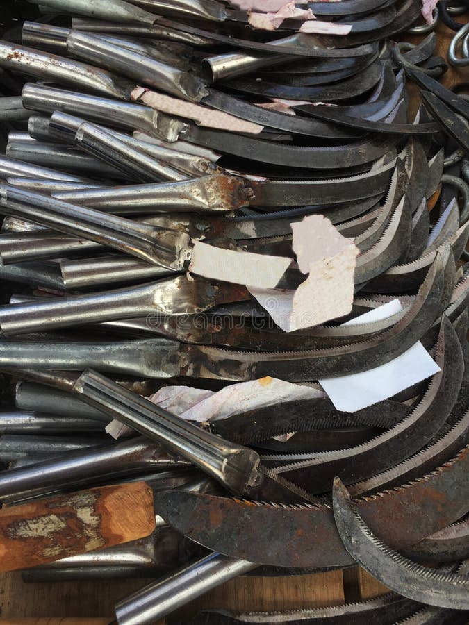 Une grande pile des scytes de vieille école qui sont employés pour couper des mauvaises herbes photographie stock Une grande pile des scytes de vieille école qui sont employés pour couper des mauvaises herbes photographie stock