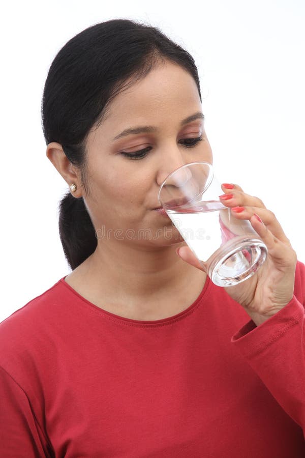 Une jeune femme boit un verre d'eau