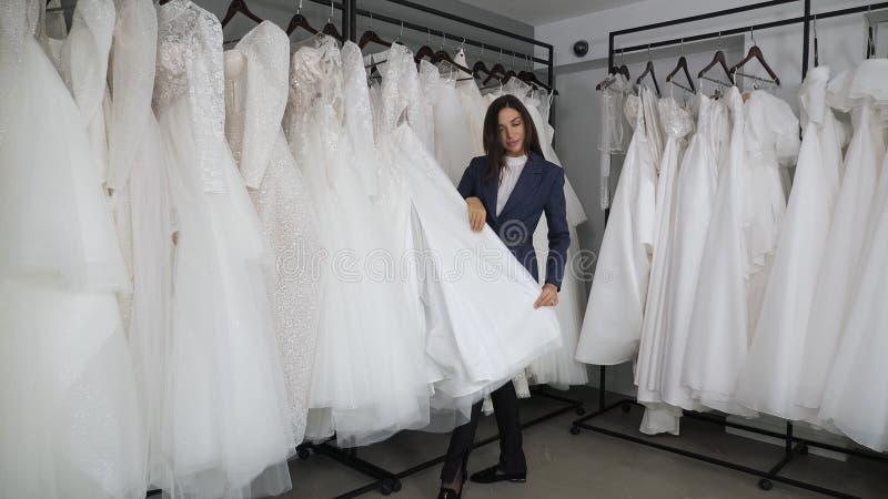 Une jeune femme luxueuse choisit une robe de mariée dans le boudoir de mariage. banque de vidéos