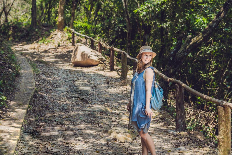 Une jeune femme marche le long d'un chemin forestier photographie stock Une jeune femme marche le long d'un chemin forestier photographie stock