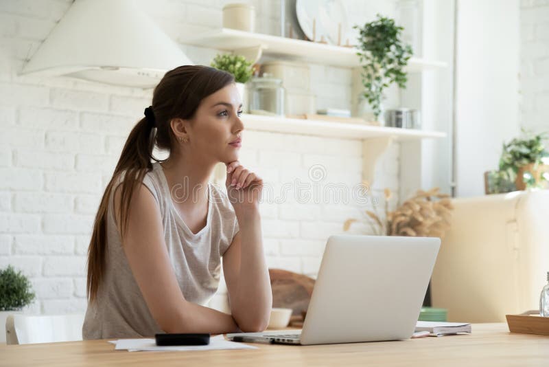 Une jeune femme réfléchie qui pense en utilisant la vision d'entreprise calculer les taux de financement. photo stock