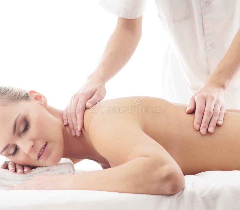 A young and attractive blond Caucasian woman laying on a massage procedure. The image is isolated on a white background. A young and attractive blond Caucasian woman laying on a massage procedure. The image is isolated on a white background.