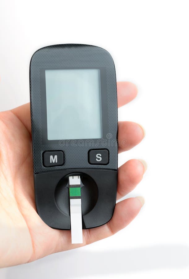 Une jeune femme tient un glucometer dans des ses mains et veut faire a photo libre de droits Une jeune femme tient un glucometer dans des ses mains et veut faire a photo libre de droits