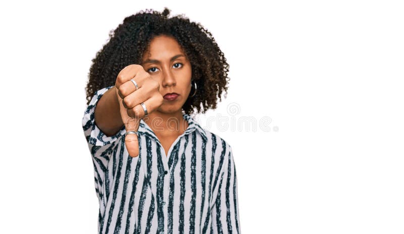 Une jeune fille afro-américaine portant des vêtements décontractés, qui a l'air malheureuse et en colère, qui montre son rejet et photo stock