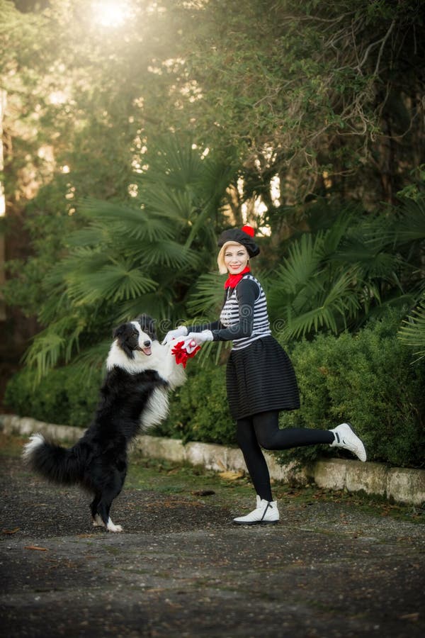 Une jeune fille et son chien border collie jouant dehors images libres de droits Une jeune fille et son chien border collie jouant dehors images libres de droits