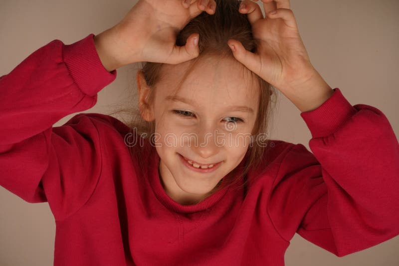 Une jeune fille joyeuse sourit avec joie en formant ses mains avec des griffes comme des animaux. Son geste imaginatif dégage de l images libres de droits