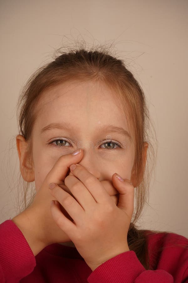 Une jeune fille se couvre la bouche avec les deux mains comme si elle gardait un secret ou mettait l'accent sur le silence. Son ex photographie stock libre de droits