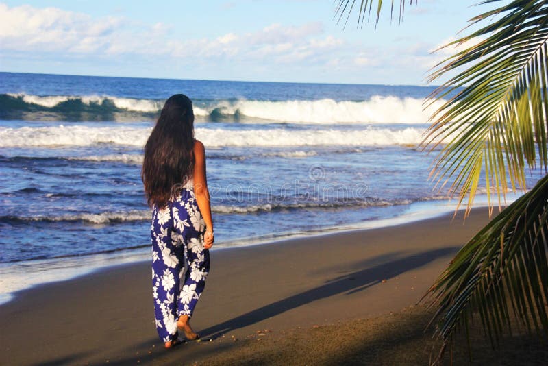 Une jeune fille tahitienne avec ses cheveux longs marchant sur la plage de Tahiti photo stock Une jeune fille tahitienne avec ses cheveux longs marchant sur la plage de Tahiti photo stock