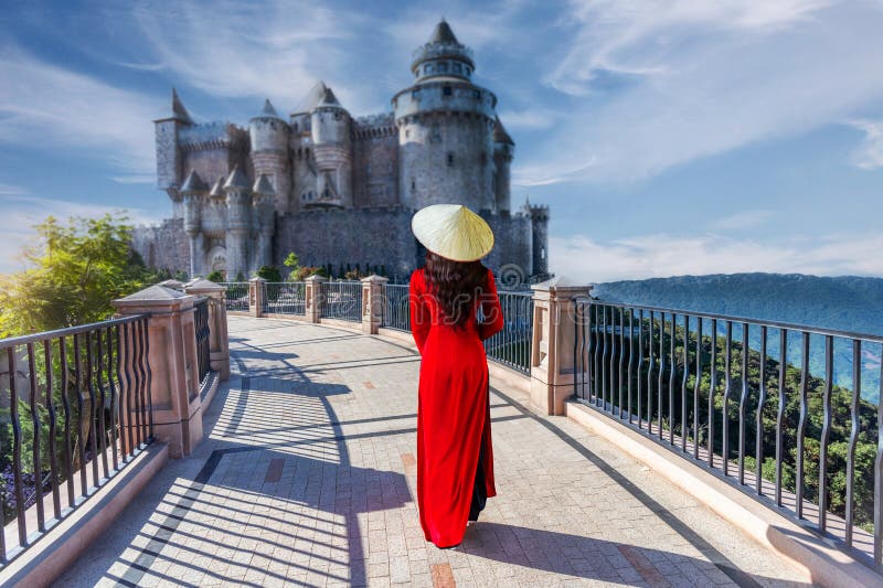 Une jeune vietnamienne habillée en rouge ao dai voyage dans un village français sur les collines de bana à danang vietnam photographie stock