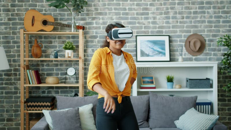 Une joyeuse afro-américaine dansant dans des lunettes de réalité virtuelle à la maison banque de vidéos
