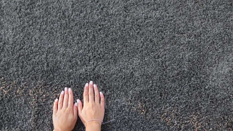 Une main de femme touchant le tapis gris de pieu intérieur banque de vidéos