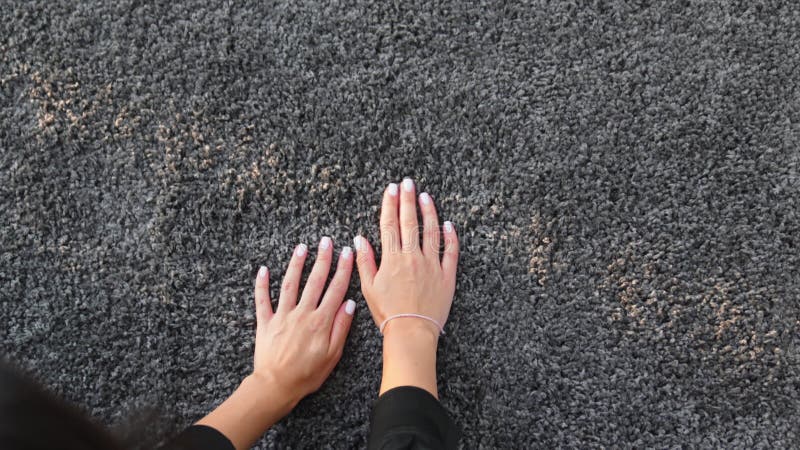 Une main de femme touchant le tapis de pieu gris intérieur banque de vidéos