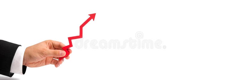 A businessman`s hand holds a red arrow up on a white background. The concept of raising and multiplying income and profits, rising prices and salaries. High demand, positive economy. banner. A businessman`s hand holds a red arrow up on a white background. The concept of raising and multiplying income and profits, rising prices and salaries. High demand, positive economy. banner