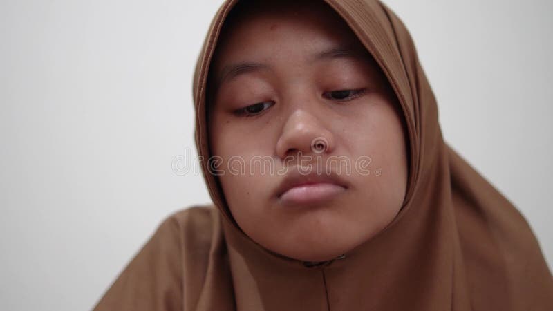 Une musulmane asiatique a l'air triste et pense à quelque chose de décevant désagréable expression solitaire clips vidéos