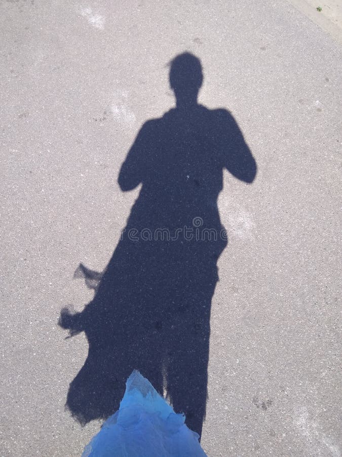 Une ombre de la femme dans la robe bleue photo libre de droits Une ombre de la femme dans la robe bleue photo libre de droits