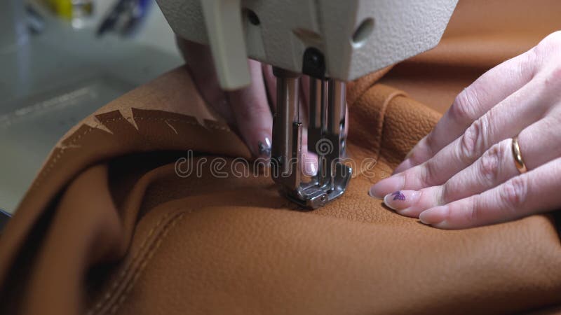 : une ouvrière couturière coud le cuir noir dans un atelier de couture Pointeaux de machine? coudre clips vidéos