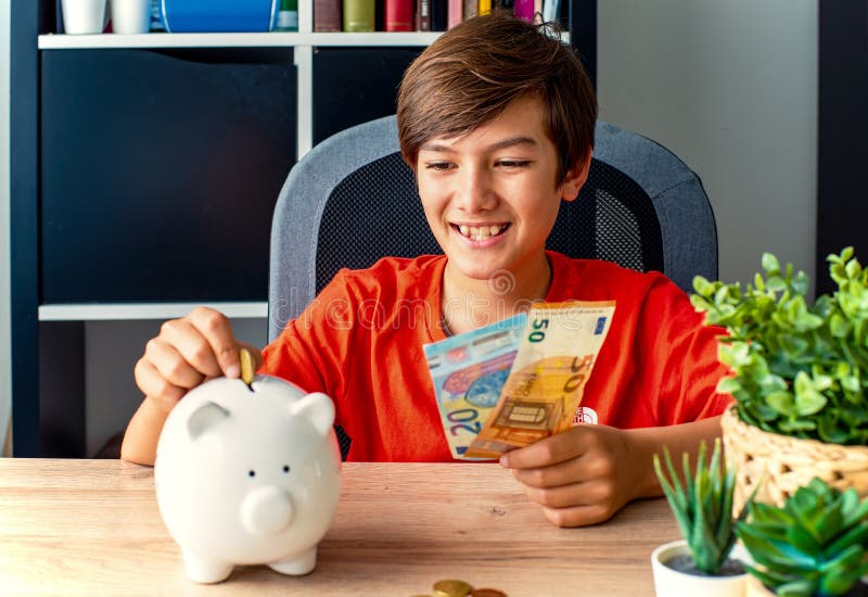 Une personne qui met des pièces dans une tirelire. happy boy insérer de l'argent pièce dans la tirelire banque d'épargne concept. images stock