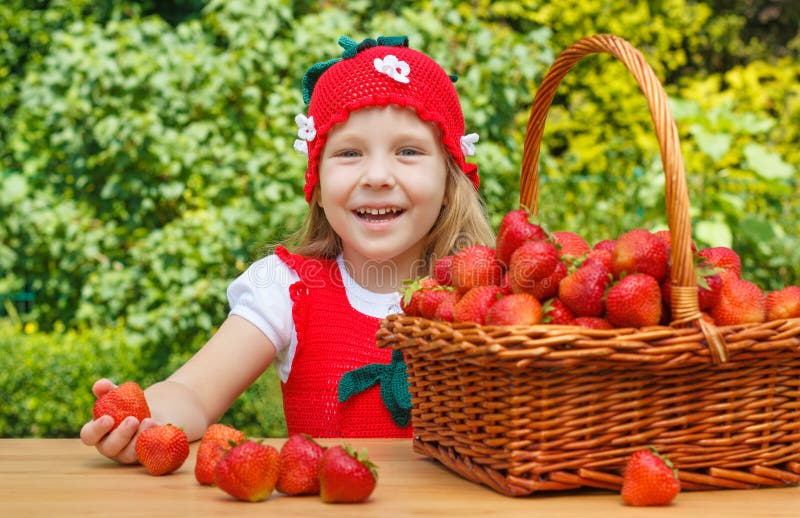 Une petite fille drôle 4 années avec un panier des fraises images stock Une petite fille drôle 4 années avec un panier des fraises images stock
