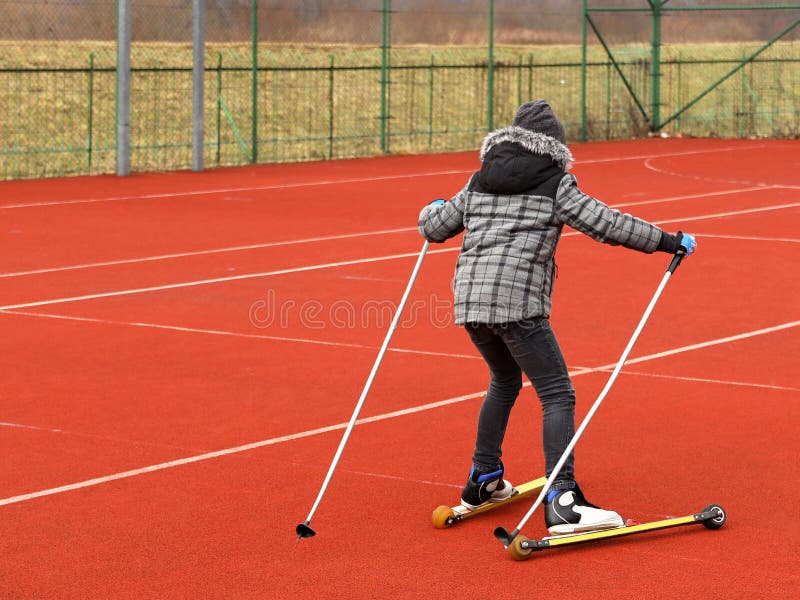 Une petite fille monte le ski de fond de formation d'été avec le RO photographie stock libre de droits Une petite fille monte le ski de fond de formation d'été avec le RO photographie stock libre de droits
