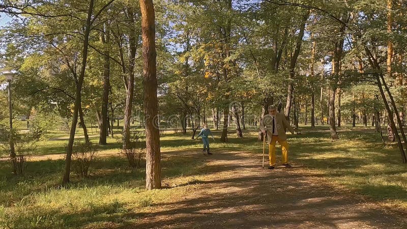 Une petite fille prend un bâton de marche de son grand-père.