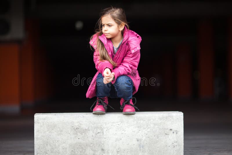 Une petite fille triste se tapissant vers le bas images libres de droits Une petite fille triste se tapissant vers le bas images libres de droits
