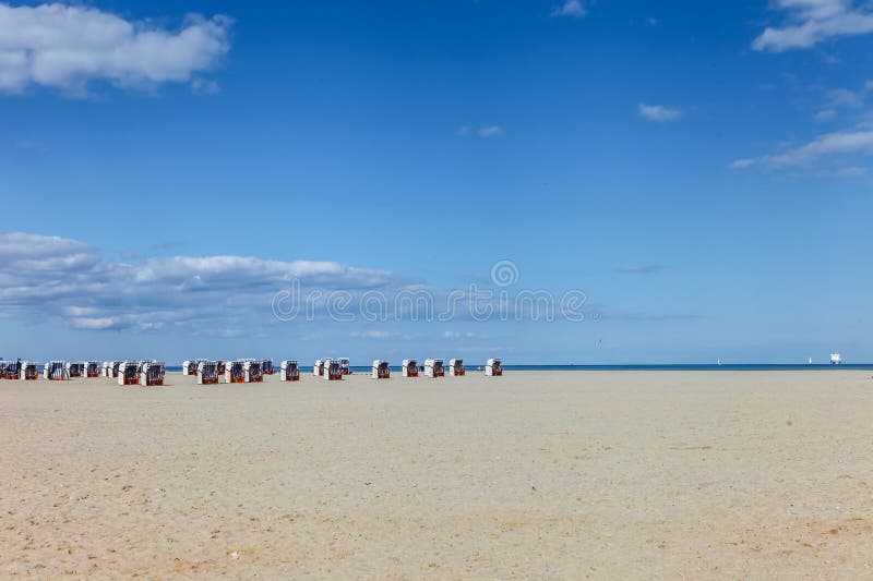 Une plage en Allemagne avec de nombreux transats et un bateau au loin image stock