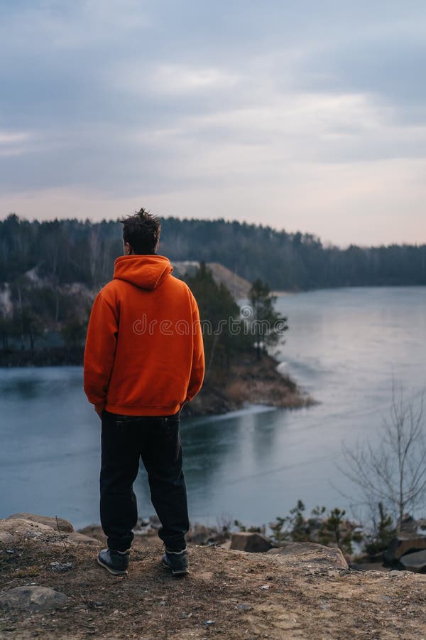 Une position de jeune homme au bord d'une falaise pose pour la cam?ra photo libre de droits Une position de jeune homme au bord d'une falaise pose pour la cam?ra photo libre de droits